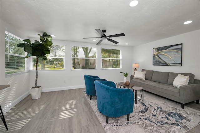 living room with light wood-type flooring and ceiling fan