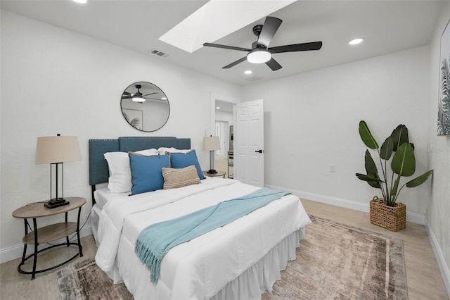 bedroom with a skylight, ceiling fan, and light wood-type flooring