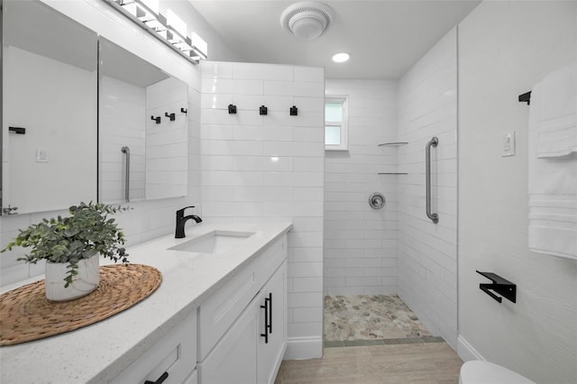 bathroom featuring a tile shower and vanity