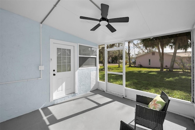 unfurnished sunroom with lofted ceiling, ceiling fan, and a wealth of natural light