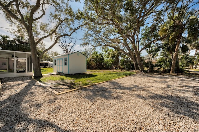 view of yard featuring a sunroom and a shed