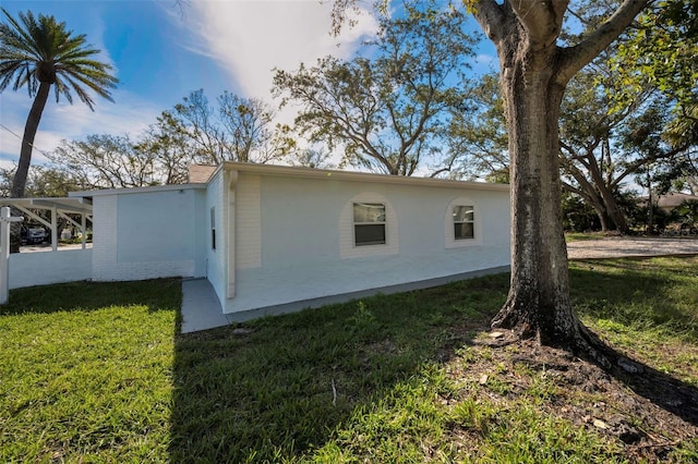 402 Pineapple St, Tarpon Springs, FL 34689 - view of side of property with a lawn and stucco siding