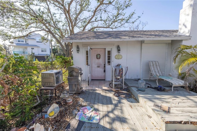 view of exterior entry with a wooden deck