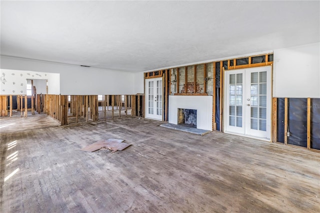 unfurnished living room with hardwood / wood-style flooring and french doors