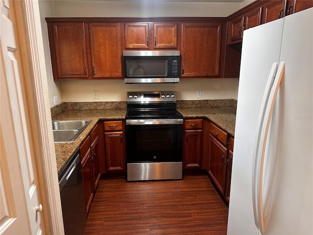 kitchen with dark wood-type flooring, stainless steel appliances, and a sink