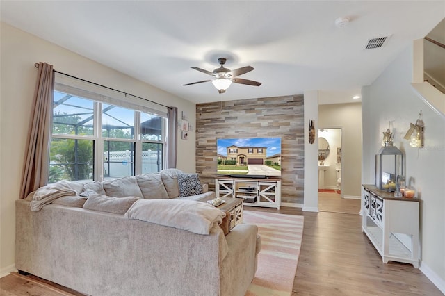 living room featuring ceiling fan and light hardwood / wood-style flooring