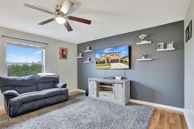 living room with light wood-type flooring and ceiling fan