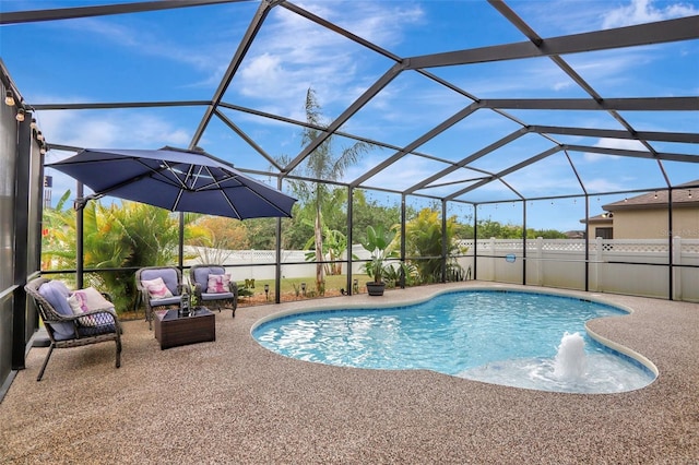 view of pool with glass enclosure and a patio