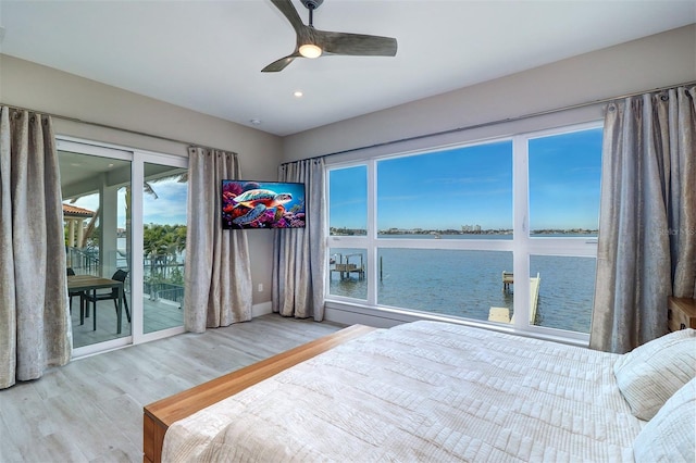 bedroom with hardwood / wood-style floors, access to outside, and ceiling fan