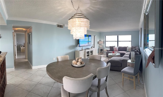 tiled dining area with a textured ceiling, crown molding, and a notable chandelier