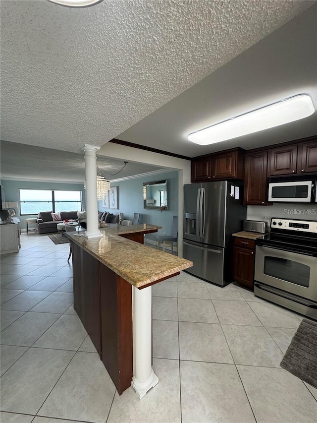 kitchen with stainless steel appliances, an inviting chandelier, decorative columns, light tile patterned floors, and dark brown cabinets