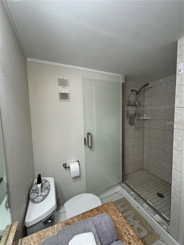 bathroom with a shower with shower door, a textured ceiling, toilet, and crown molding