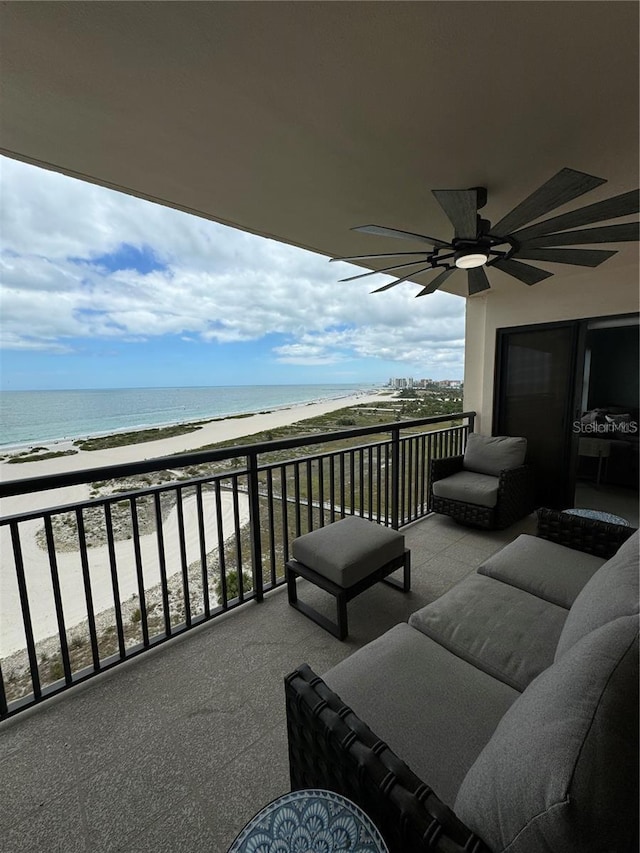 balcony featuring ceiling fan, a water view, and a beach view