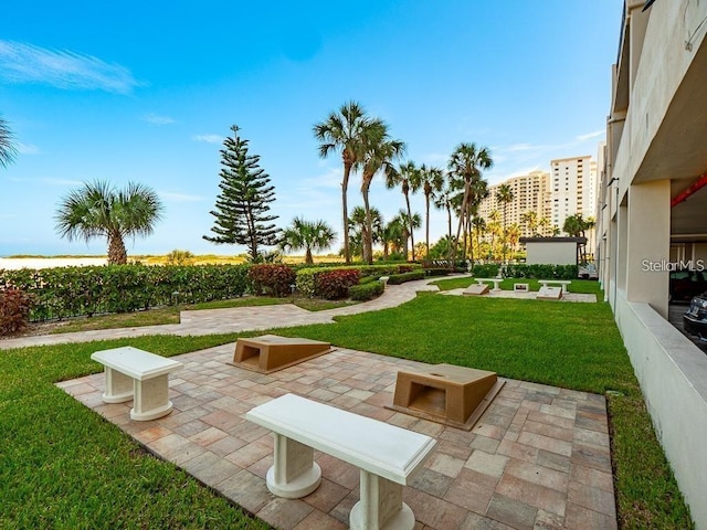 view of home's community with a lawn and a patio area