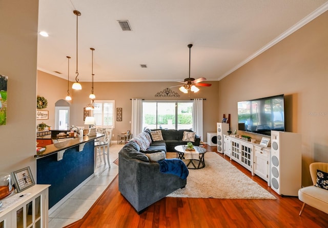 living room with sink, ceiling fan, ornamental molding, and light wood-type flooring