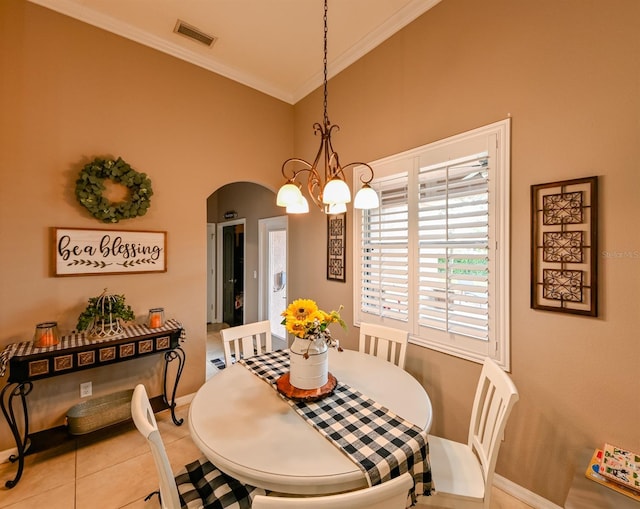 tiled dining space featuring a chandelier and crown molding