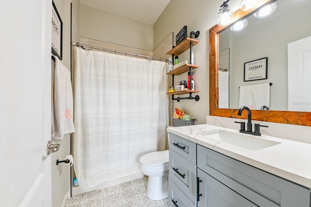 bathroom with toilet, vanity, and tile patterned flooring