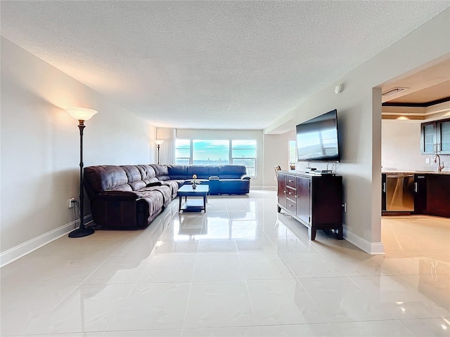 tiled living room featuring sink and a textured ceiling