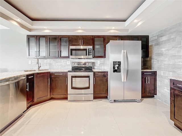 kitchen with light stone counters, sink, light tile patterned floors, and appliances with stainless steel finishes