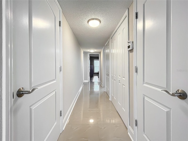 hallway with a textured ceiling