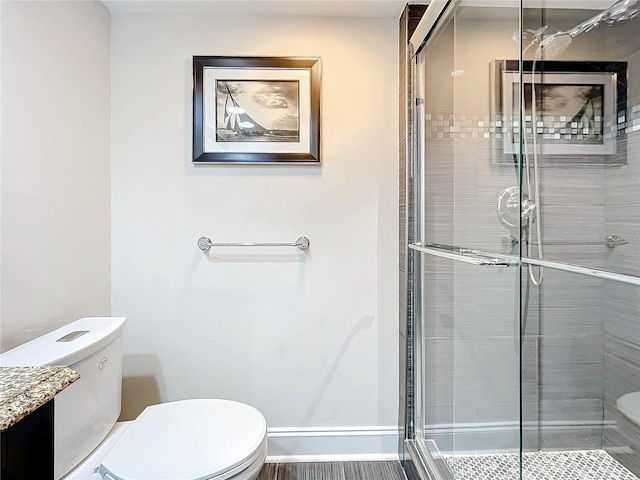 bathroom with a shower with shower door and toilet