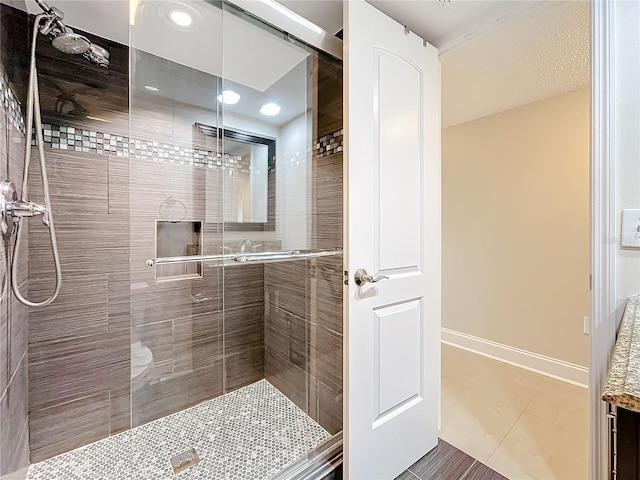 bathroom with tile patterned flooring and an enclosed shower