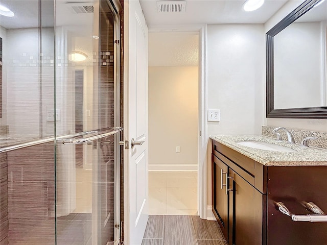 bathroom featuring vanity and an enclosed shower