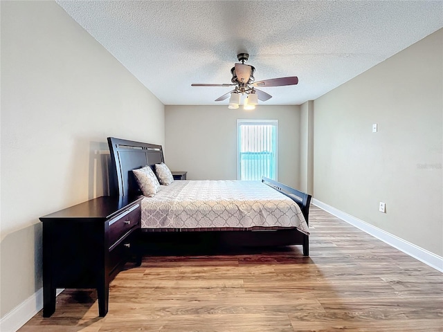 bedroom with ceiling fan, a textured ceiling, and light wood-type flooring