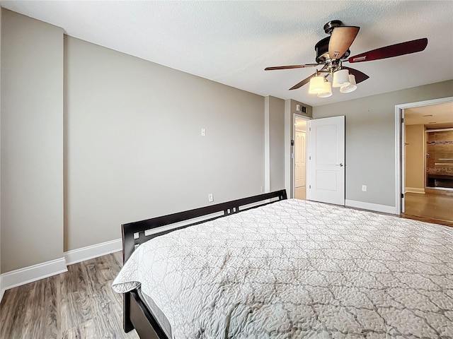 unfurnished bedroom featuring ceiling fan, wood-type flooring, and a textured ceiling