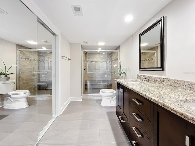 bathroom with tile patterned floors, vanity, toilet, and a shower with shower door