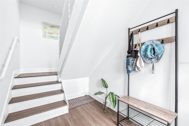 stairway with wood-type flooring and vaulted ceiling