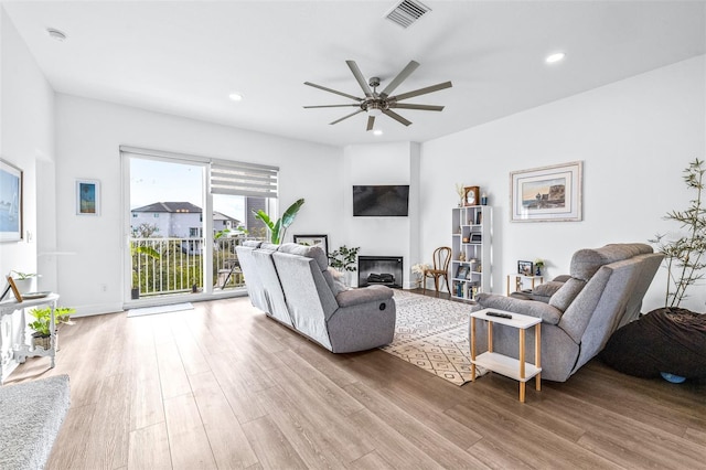 living room with ceiling fan and light hardwood / wood-style flooring