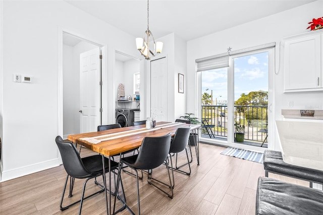 dining space with light wood-type flooring, an inviting chandelier, and washing machine and clothes dryer