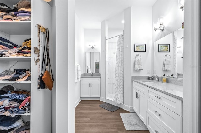 bathroom with wood-type flooring, vanity, and walk in shower