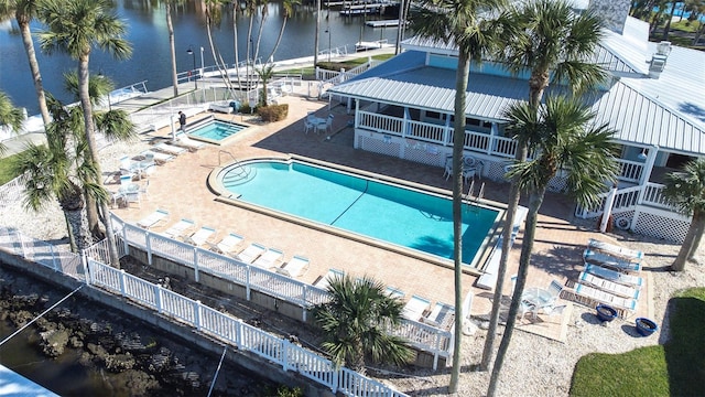 view of pool with a community hot tub, a water view, and a patio area