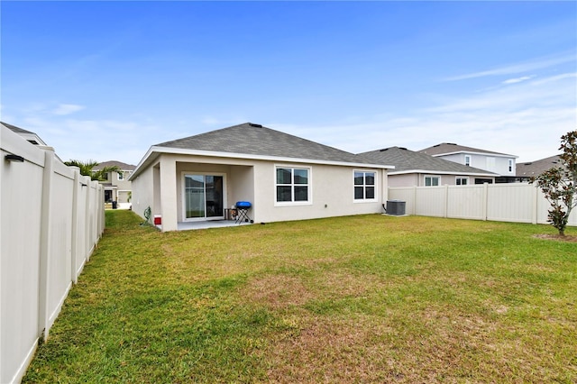 back of property with cooling unit, a patio, and a yard