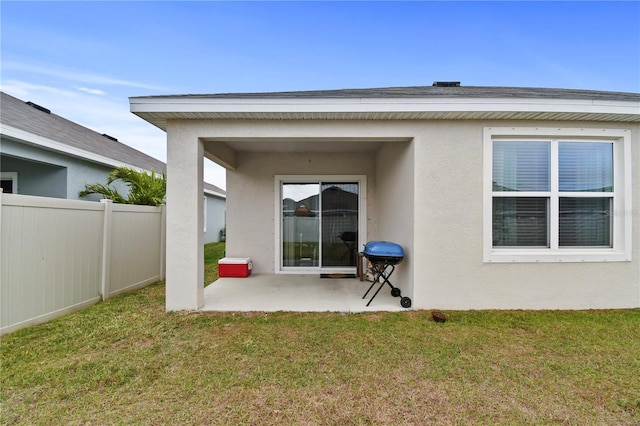 rear view of property with a lawn and a patio area