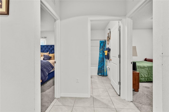 hallway featuring light colored carpet