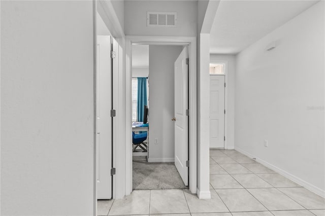 hallway featuring light tile patterned floors and a healthy amount of sunlight