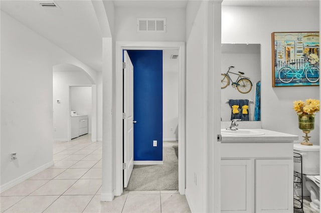 bathroom with washer / dryer, vanity, and tile patterned floors