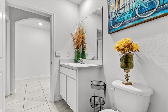 bathroom with toilet, tile patterned floors, and vanity