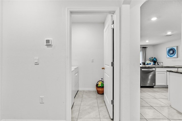 hallway with washer and clothes dryer and light tile patterned floors