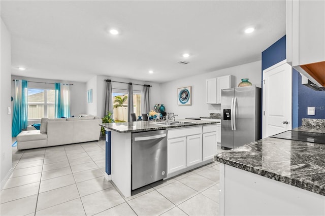 kitchen featuring stainless steel appliances, dark stone countertops, white cabinets, and sink