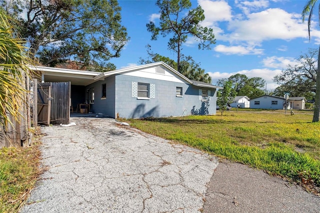 view of home's exterior with a carport and a yard