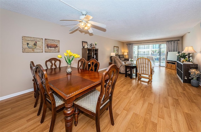 dining space with ceiling fan, light hardwood / wood-style floors, and a textured ceiling