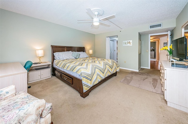 bedroom with ceiling fan, a textured ceiling, and light carpet