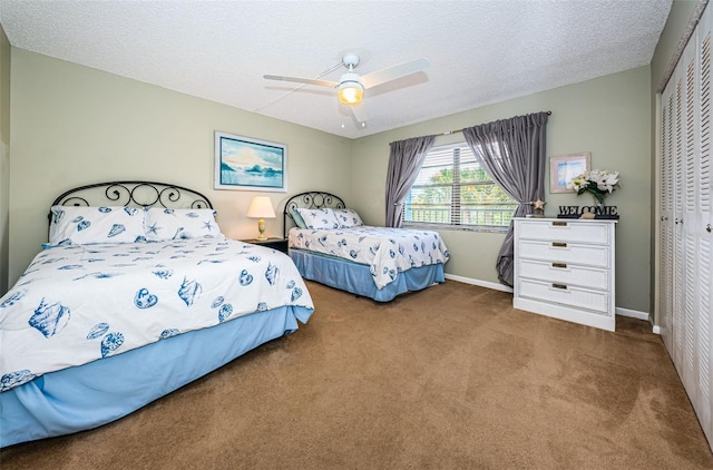 bedroom featuring a closet, carpet flooring, a textured ceiling, and baseboards