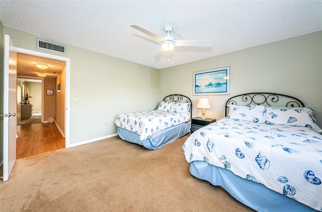 bedroom with visible vents, a ceiling fan, a textured ceiling, carpet floors, and baseboards