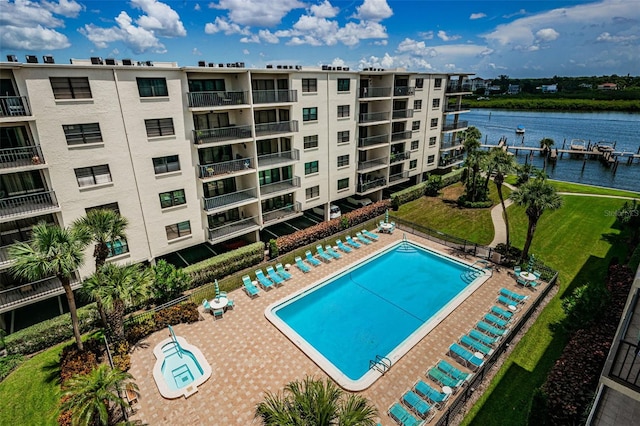 view of swimming pool featuring a patio area and a water view