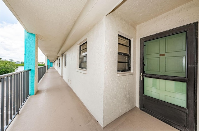 doorway to property featuring stucco siding and a balcony